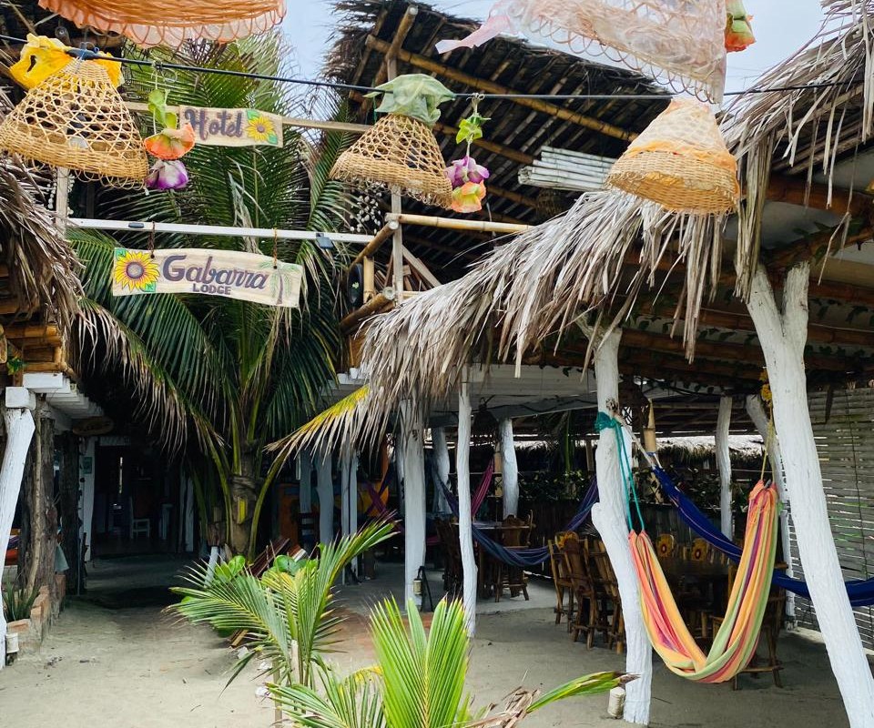 Entrada de Hotel Gabarra Lodge en Briceño, Manabí: restaurante de playa con hamacas y palmeras